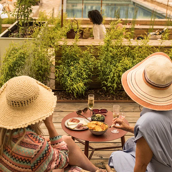 Poolhäng & avkoppling på Hjortviken Gäster som njuter av dryck och snacks vid poolområdet på Hjortviken i naturnära spa- och retreatmiljö.